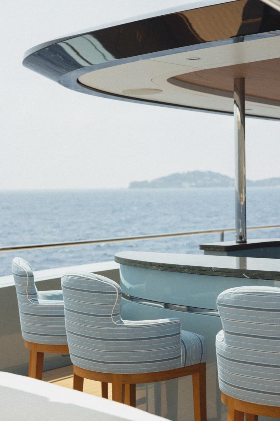 Yacht bar deck with blue striped chairs and ocean view